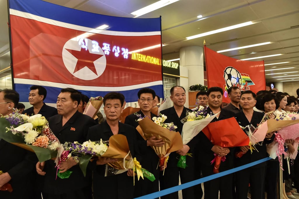 People hold flowers and flags as they wait for the arrival of Naegohyang Women’s FC players in Pyongyang on May 26 after their victory in the AFC Women’s Champions League. Photo: AFP