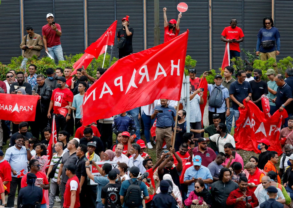 Anwar Ibrahim’s supporters hold Pakatan Harapan flags as they celebrate his swearing in as prime minister outside the National Palace in Kuala Lumpur in 2022. Photo: Reuters