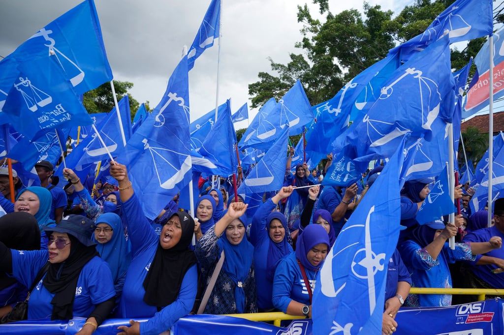 Supporters of Malaysia’s Barisan Nasional wave flags outside a nomination centre in Langkawi in 2022. Photo: AP