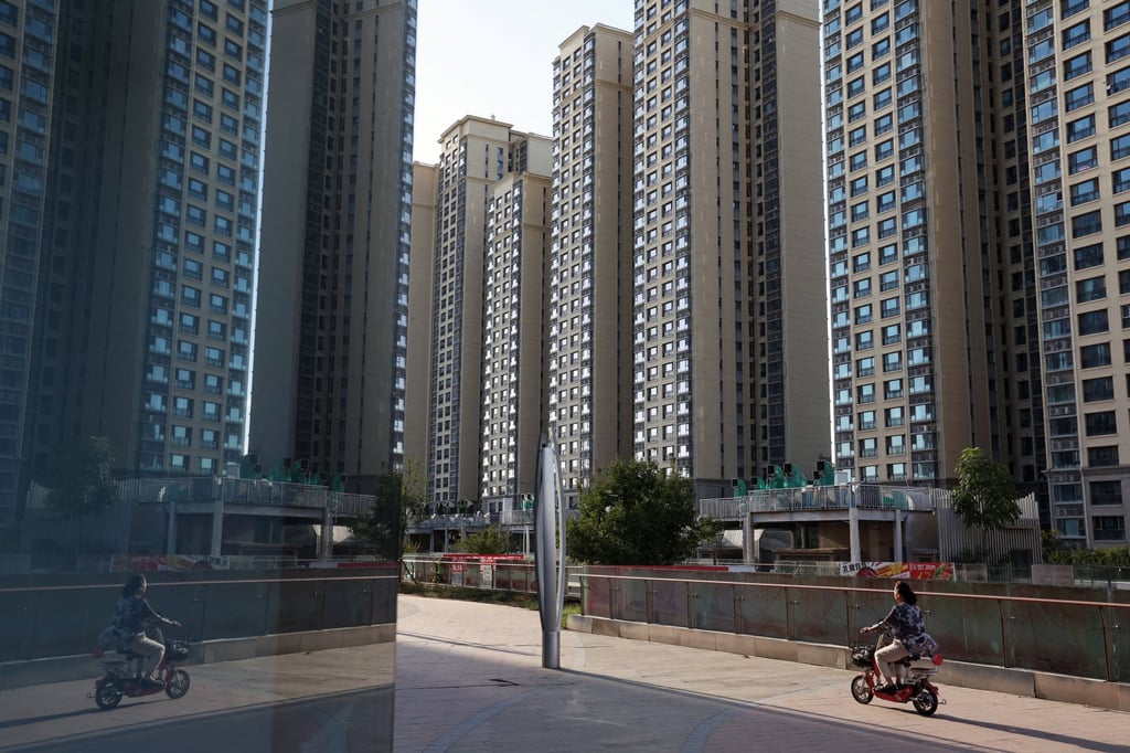 A woman rides a scooter past residential buildings at a housing complex in Beijing. Photo: Reuters A woman rides a scooter past residential buildings at a housing complex in Beijing. Photo: Reuters