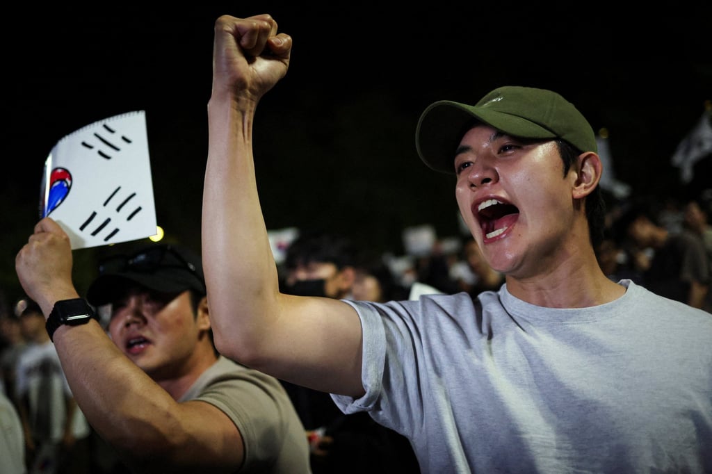 A demonstrator raises his fist as people surround a vote-counting centre during a protest in Seoul, South Korea, on Saturday. Photo: Reuters A demonstrator raises his fist as people surround a vote-counting centre during a protest in Seoul, South Korea, on Saturday. Photo: Reuters