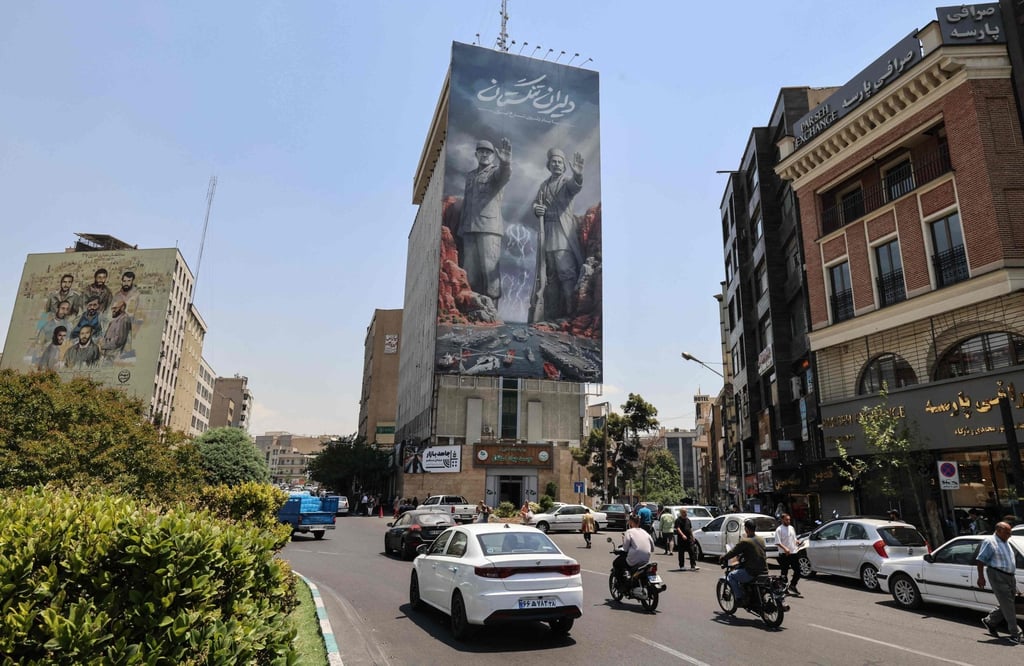 Commuters drive past a large banner depicting the closure of the Strait of Hormuz in Tehran on Wednesday. Photo: AFP
