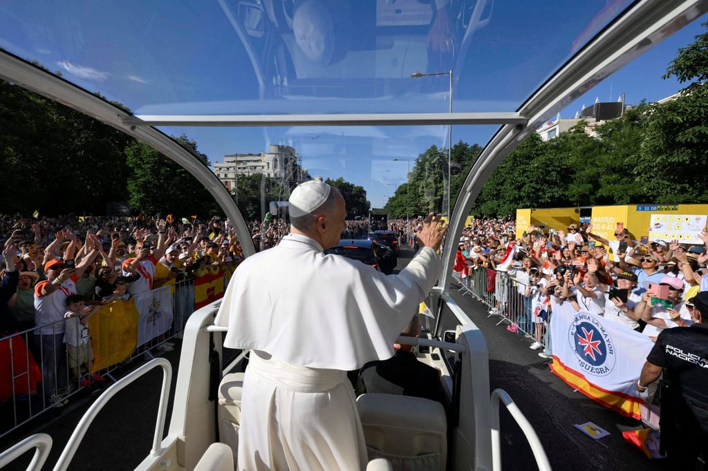 Pope Leo waves to crowds from the Popemobile. Photo: Vatican Media via Reuters