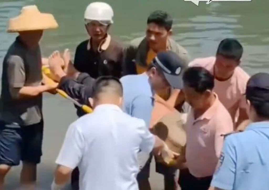 Qin is helped ashore on a stretcher by the two fishermen and other rescuers Photo: Handout Qin is helped ashore on a stretcher by the two fishermen and other rescuers Photo: Handout