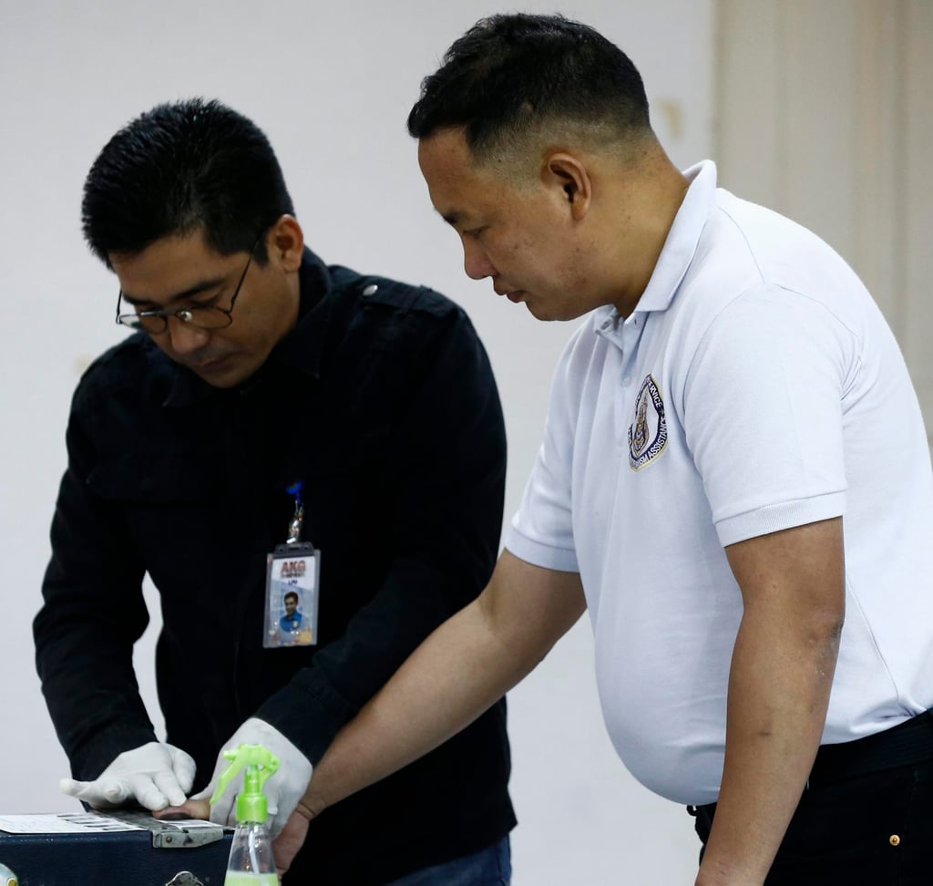Former senior police officer Ricky Santa Isabel (right) is fingerprinted after his arrest for the killing of South Korean businessman Jee Ick-joo at the police headquarters in Quezon City in January 2017. Photo: EPA