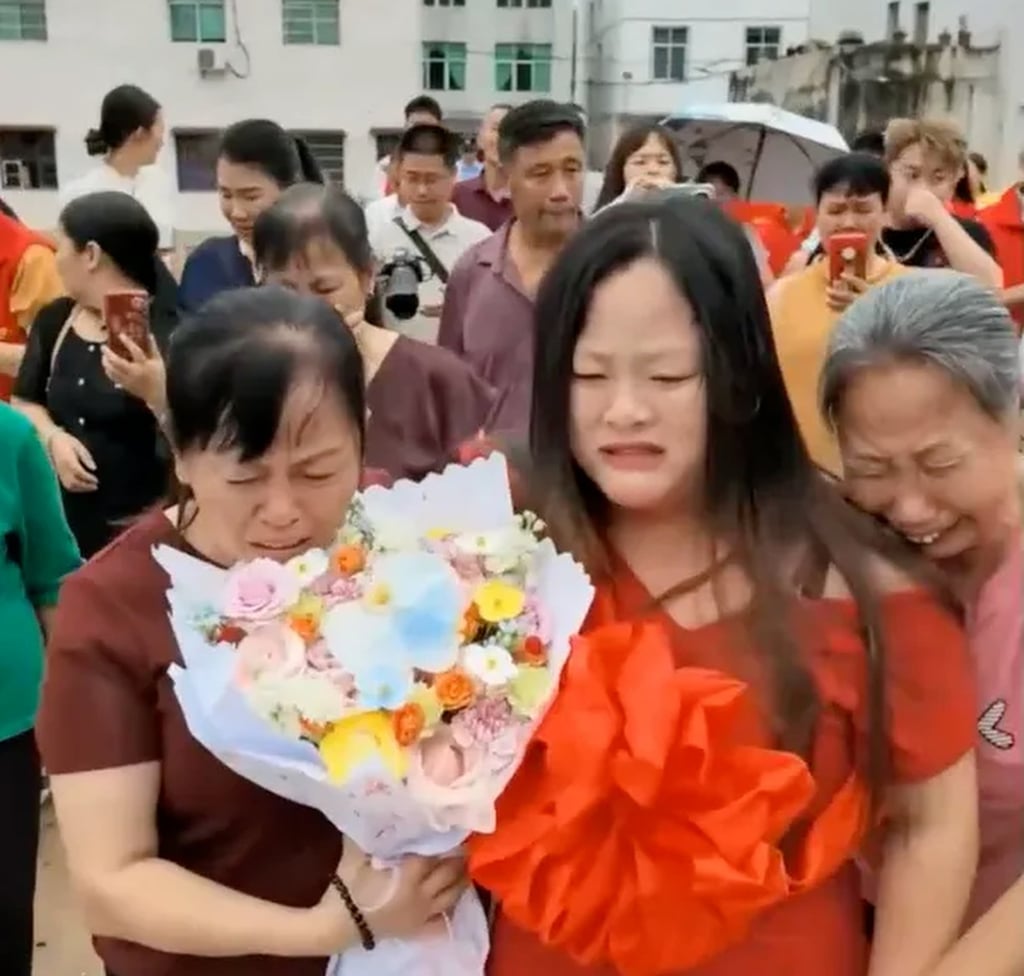 Liu, in red, is presented with flowers by two tearful members of her birth family. Photo: QQ.com Liu, in red, is presented with flowers by two tearful members of her birth family. Photo: QQ.com