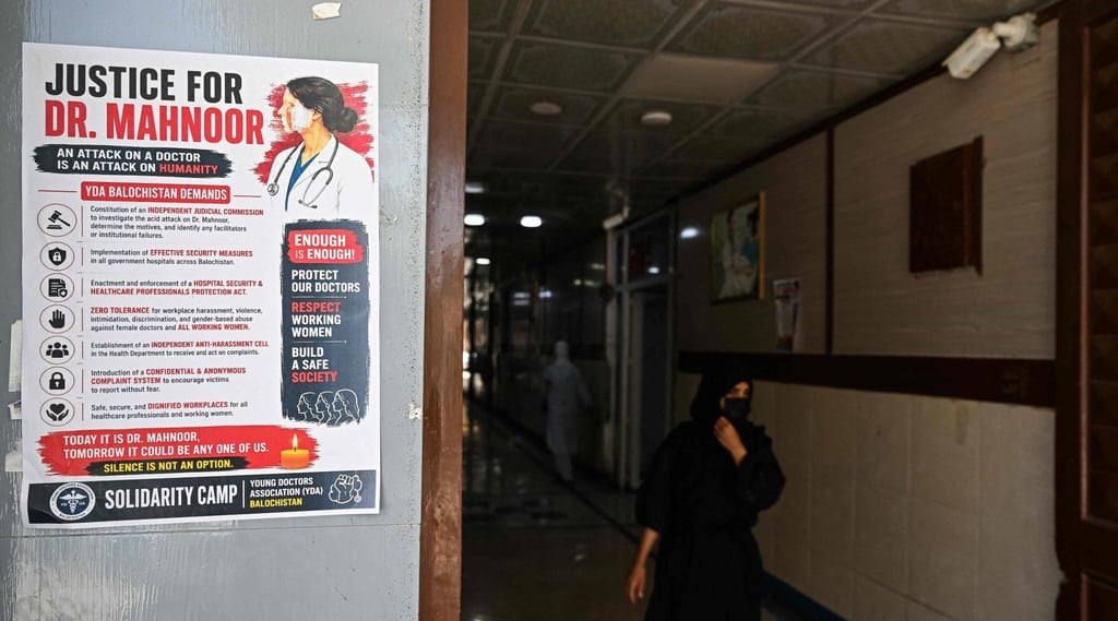 A woman walks past a poster displayed by medical practitioners to express solidarity with Mahnoor Nasir on Tuesday. Photo: AFP
