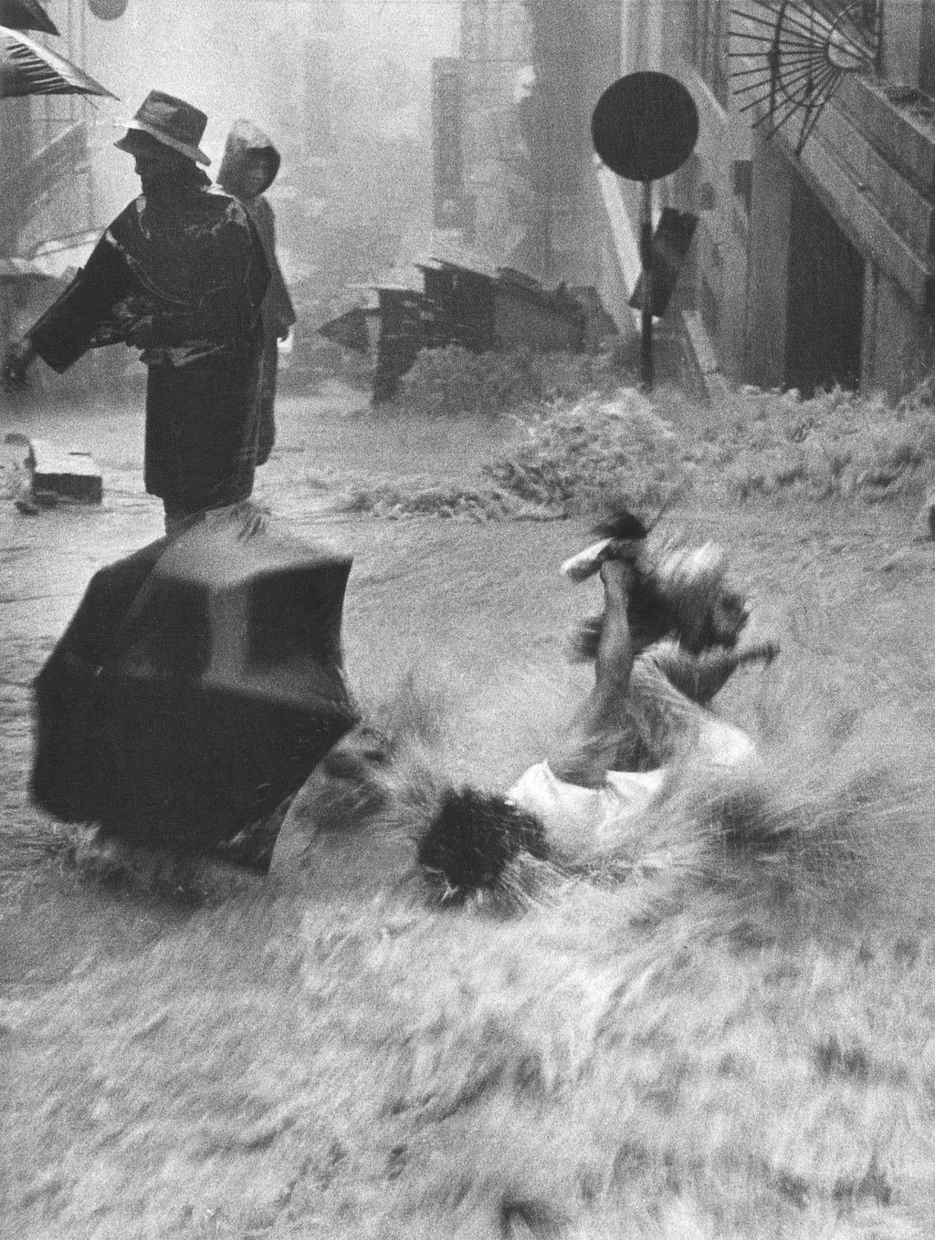 A woman falls into the floodwaters at the junction of Third and Centre Street in Sai Ying Pun under heavy rainstorms spread across Hong Kong in June 1966. Photo: Chan Kiu