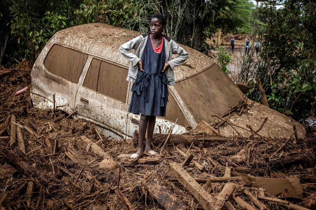 A girl stands next to a car buried in mud after flash floods in the Kenyan village of Kamuchiri in April 2024, during a wet season made worse by El Nino. Photo: AFP A girl stands next to a car buried in mud after flash floods in the Kenyan village of Kamuchiri in April 2024, during a wet season made worse by El Nino. Photo: AFP