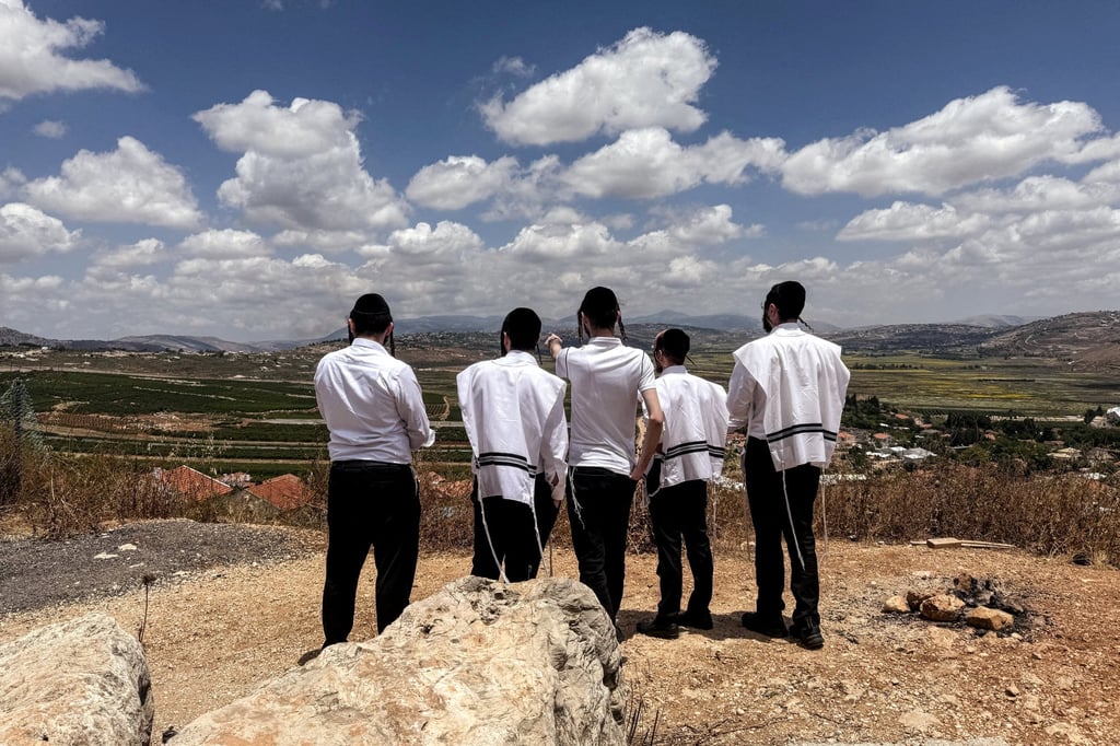 A group of ultra-Orthodox Jewish men looks towards southern Lebanon, from the Israeli side of the Israel-Lebanon border, in northern Israel on Sunday. Photo: Reuters