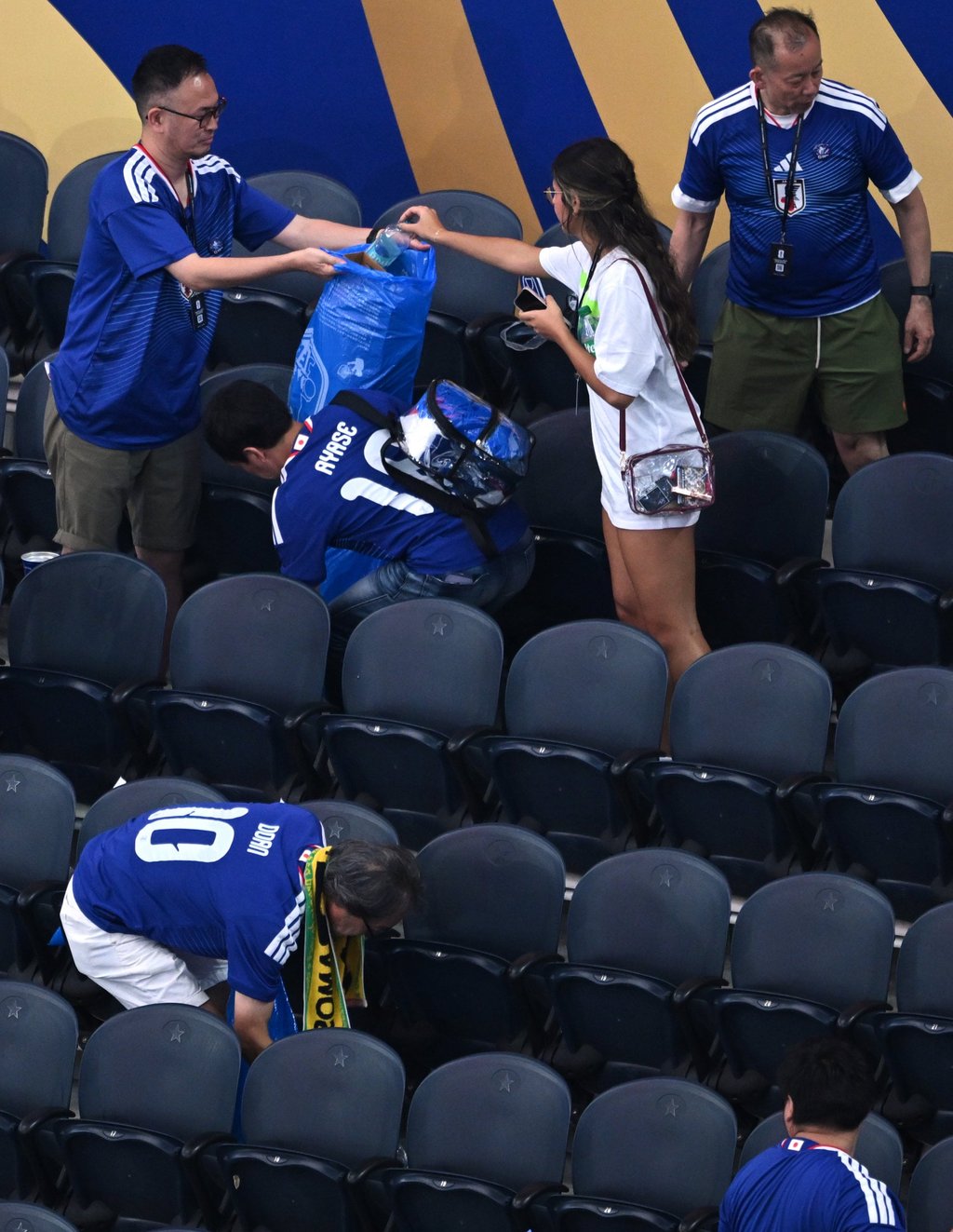 Japan fans clean up rubbish in the stadium following a World Cup match on Sunday. Photo: AP Japan fans clean up rubbish in the stadium following a World Cup match on Sunday. Photo: AP