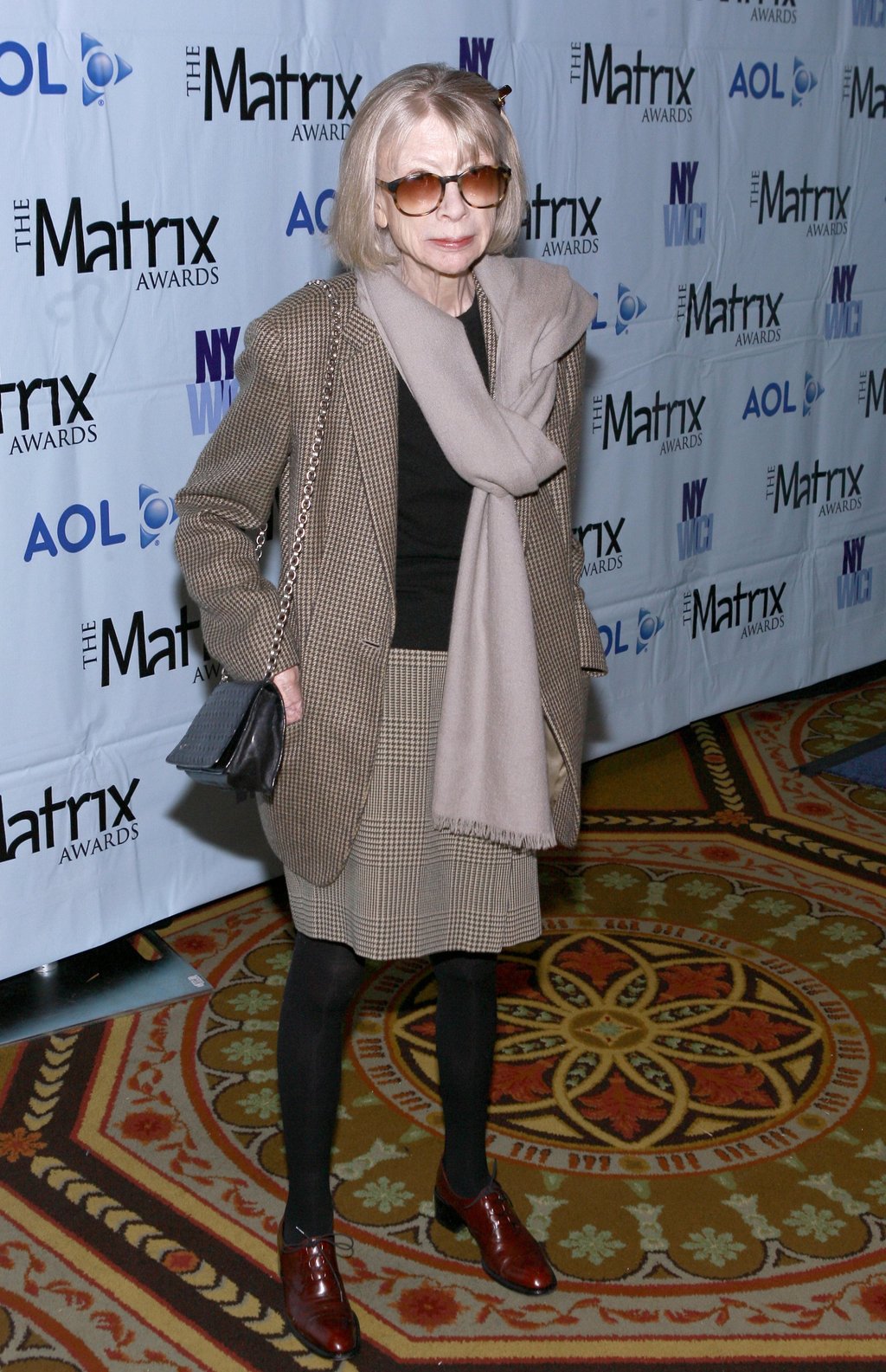 Joan Didion, pictured in 2007, wearing a checked blazer and a knee-length skirt. Photo: WireImage