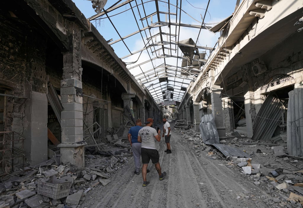 People returning to their village following the announcement of an initial ceasefire agreement between the US and Iran walk in a destroyed market shop in Nabatiyeh town, southern Lebanon, on Tuesday. Photo: AP
