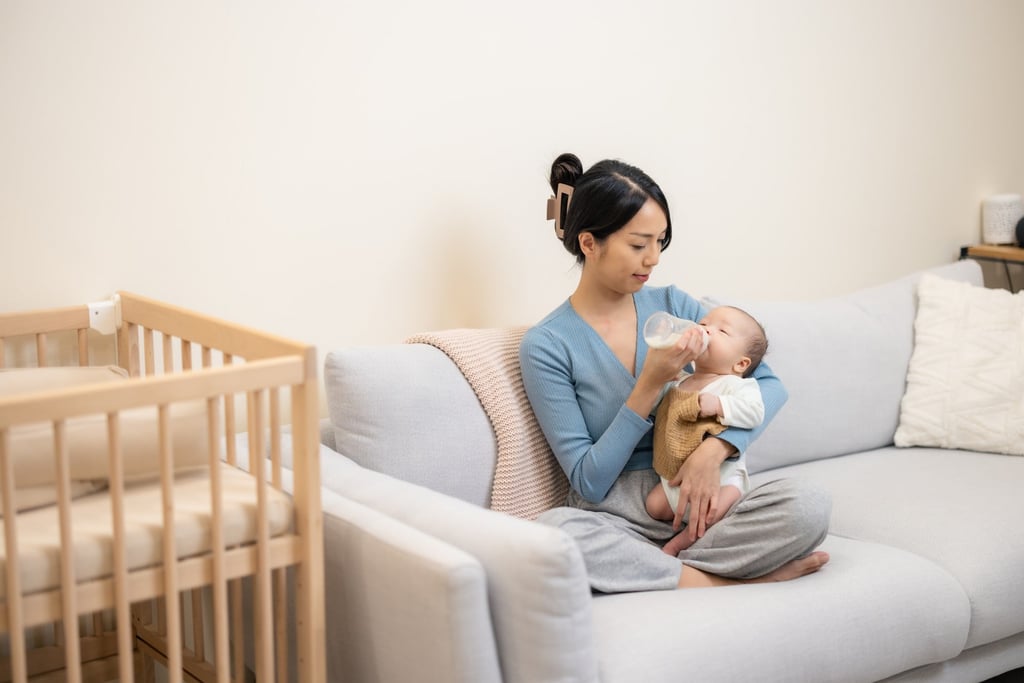 A mother feeds her newborn baby with milk from a bottle at home. Photo: Shutterstock A mother feeds her newborn baby with milk from a bottle at home. Photo: Shutterstock