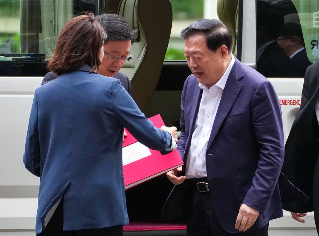 John Lee hands Xia Baolong a gift at the Shenzhen Bay control point. Photo: Jelly Tse John Lee hands Xia Baolong a gift at the Shenzhen Bay control point. Photo: Jelly Tse