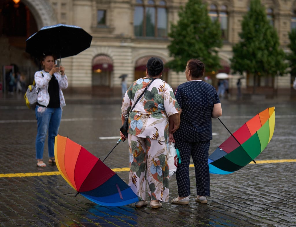 Tourists pose for a photo in the rain at Moscow’s Red Square on Sunday. Photo: AP