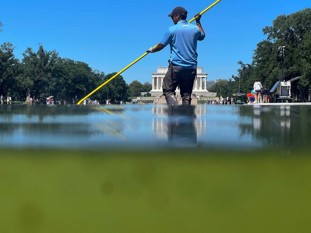 A National Park Service employee uses a vacuum pump to clean algae off the bottom of the newly repainted Lincoln Memorial Reflecting Pool in Washington on Tuesday. Photo: AFP