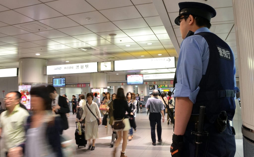 A policeman keeps on eye on commuters at a Tokyo railway station. Photo: AFP A policeman keeps on eye on commuters at a Tokyo railway station. Photo: AFP