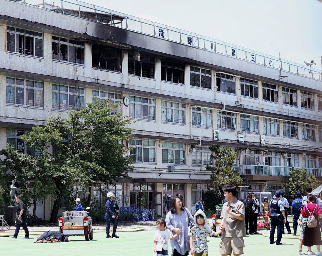 Parents take their children back from Takinogawa Dai-san Elementary School on Friday. Photo: Jiji Press/AFP Parents take their children back from Takinogawa Dai-san Elementary School on Friday. Photo: Jiji Press/AFP