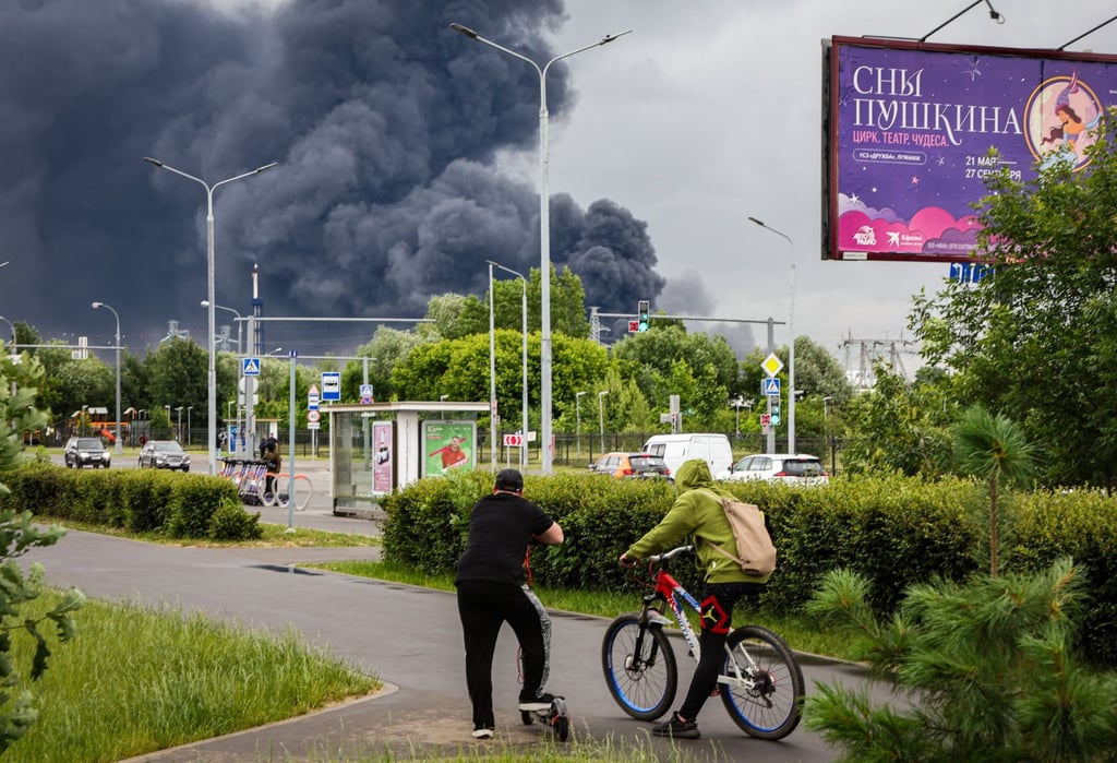 Muscovites watch smoke billow in the background following a Ukrainian drone strike on Thursday. Photo: EPA Muscovites watch smoke billow in the background following a Ukrainian drone strike on Thursday. Photo: EPA