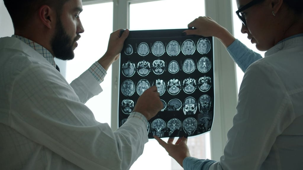 A doctor talks over a set of Ezra full-body MRI scans. Photo: Handout
