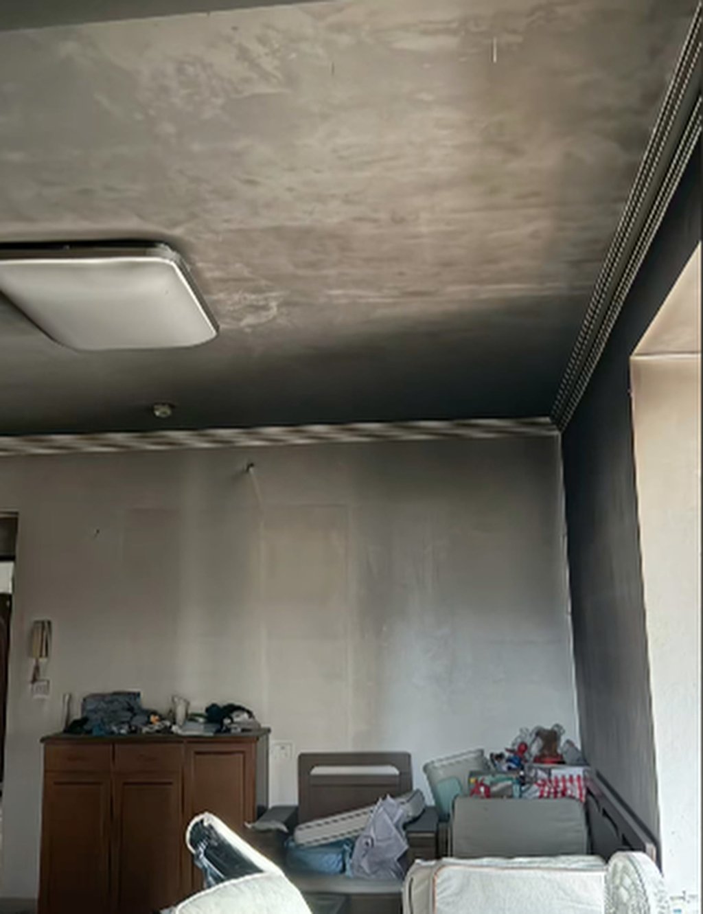Alors que le plafond et les murs du salon étaient noircis par les flammes, certains meubles ont miraculeusement survécu intacts. Photo : Douyin