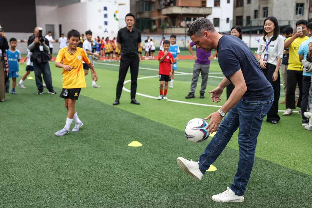 Michael Owen also visited a primary school, where he offered guidance to local students. Photo: Xinhua