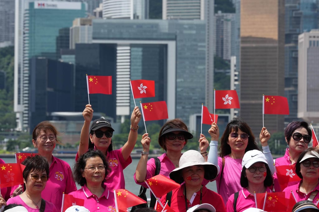 Residents wave China and Hong Kong flags at the Tsim Sha Tsui waterfront. Photo: Jelly Tse Residents wave China and Hong Kong flags at the Tsim Sha Tsui waterfront. Photo: Jelly Tse