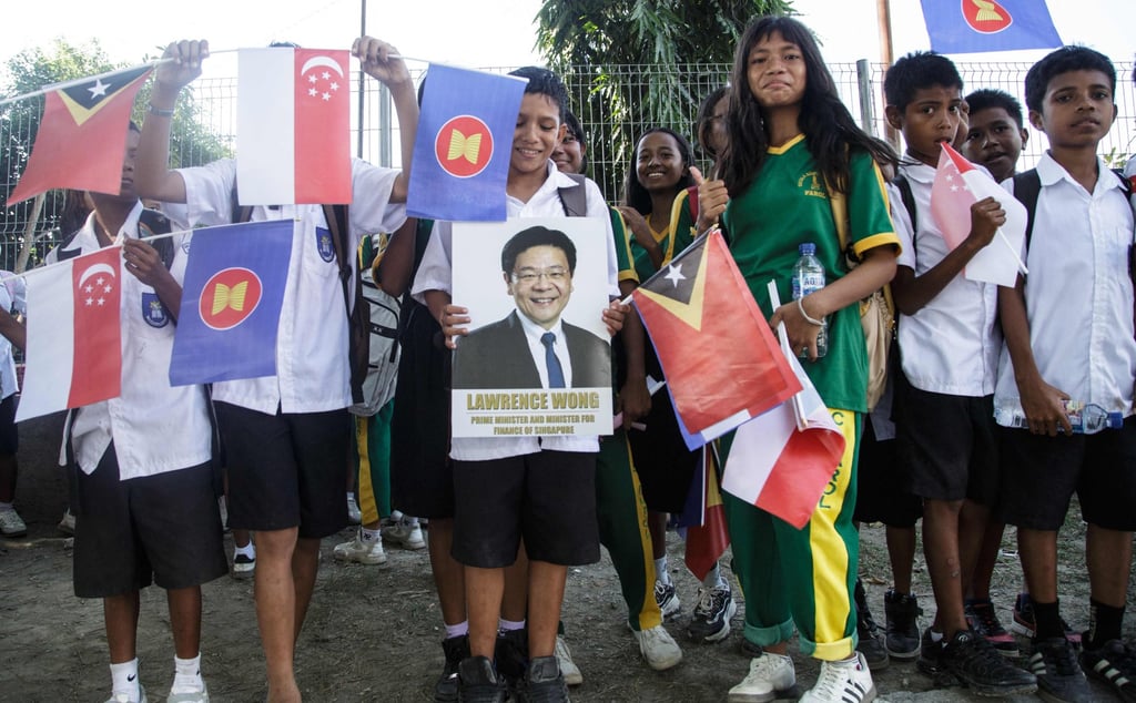Students wait to welcome Singapore’s Prime Minister Laurence Wong along a road in Dili on Thursday. Photo: AFP Students wait to welcome Singapore’s Prime Minister Laurence Wong along a road in Dili on Thursday. Photo: AFP