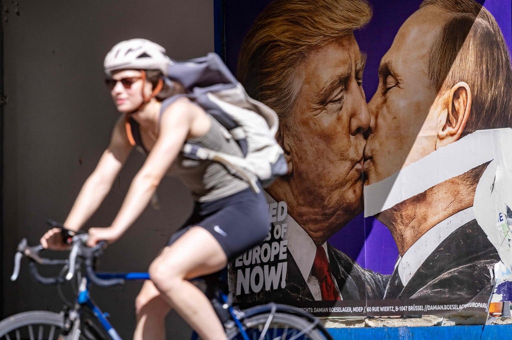 A woman cycles past a poster in Berlin in June depicting US President Donald Trump and Russian President Vladimir Putin kissing. Photo: AFP A woman cycles past a poster in Berlin in June depicting US President Donald Trump and Russian President Vladimir Putin kissing. Photo: AFP