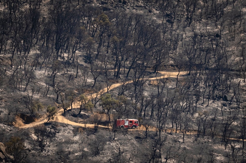 A fire truck works in a burnt area near a residential area in Catalonia, Spain, on Sunday. Photo: EPA