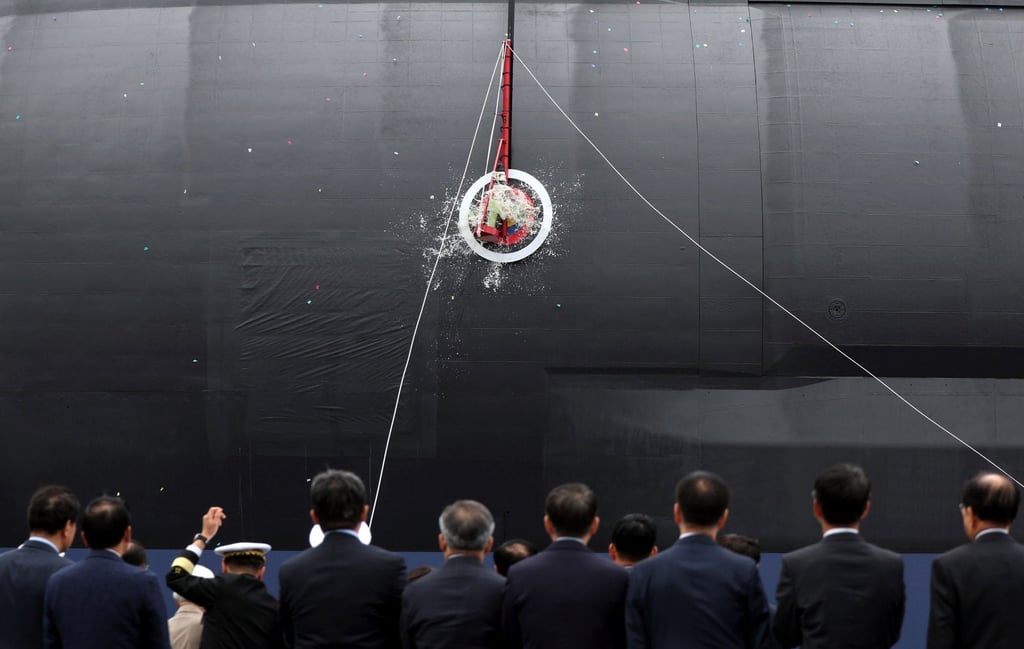 A bottle of champagne is smashed on the hull of South Korea’s first 3,600 tonne-class naval submarine during a ceremony at the Hanwha Ocean dockyard on October 22, 2025. Photo: Yonhap/EPA A bottle of champagne is smashed on the hull of South Korea’s first 3,600 tonne-class naval submarine during a ceremony at the Hanwha Ocean dockyard on October 22, 2025. Photo: Yonhap/EPA