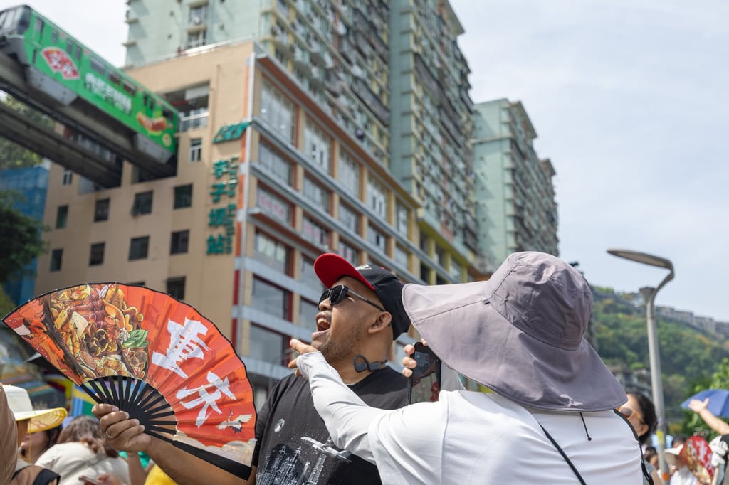 A foreign tourist poses near a monorail as it passes through a residential building in Chongqing, southwest China, April 23, 2026. Photo: Xinhua A foreign tourist poses near a monorail as it passes through a residential building in Chongqing, southwest China, April 23, 2026. Photo: Xinhua
