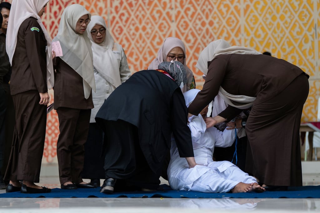 Officials help an unmarried woman get up after she was publicly caned for kissing during a TikTok livestream in Banda Aceh, Indonesia, on July 2. Photo: AP Officials help an unmarried woman get up after she was publicly caned for kissing during a TikTok livestream in Banda Aceh, Indonesia, on July 2. Photo: AP