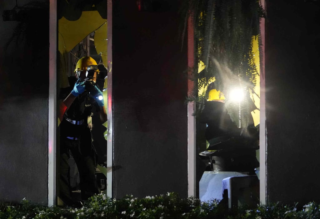 Forensic police officers investigate a fire in a Bangkok pub on Monday. Photo: AP