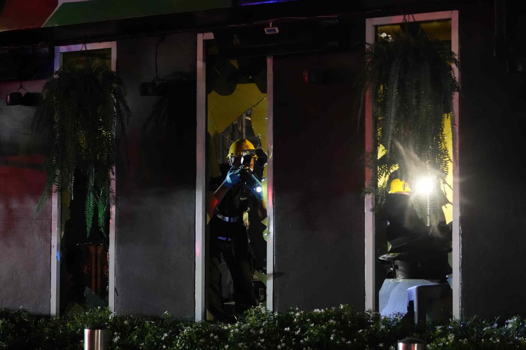 Policiais forenses examinam a cena de um incêndio em Bangkok na segunda-feira. Foto: AP Policiais forenses examinam a cena de um incêndio em Bangkok na segunda-feira. Foto: AP