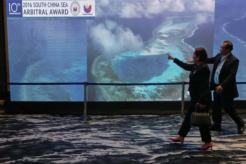 People pass by an electronic board showing areas of the disputed South China Sea during a conference in Manila on Friday to mark the 10th anniversary of a 2016 arbitration ruling which invalidated China’s expansive claims. Photo: AP People pass by an electronic board showing areas of the disputed South China Sea during a conference in Manila on Friday to mark the 10th anniversary of a 2016 arbitration ruling which invalidated China’s expansive claims. Photo: AP