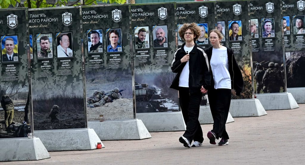 Young people walk past the Alley of Fallen Heroes in a district of Kyiv on Sunday. Photo: AFP Young people walk past the Alley of Fallen Heroes in a district of Kyiv on Sunday. Photo: AFP