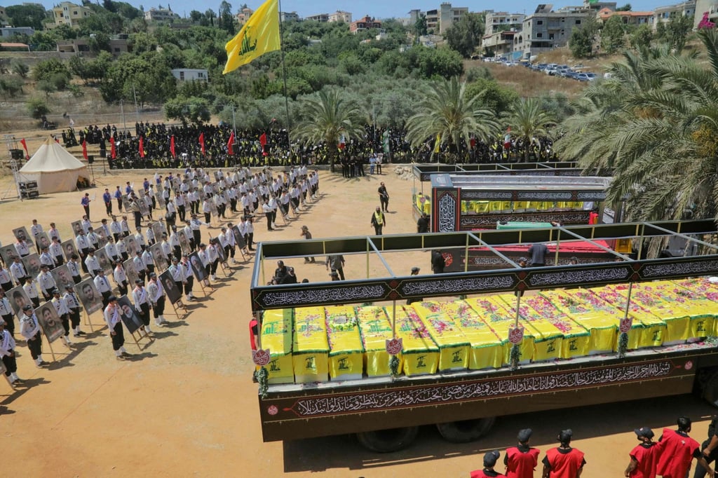 The caskets of Hezbollah fighters killed during clashes with the Israeli army are pictured to the right and left of a mock coffin of Iran’s slain supreme leader, Ayatollah Ali Khamenei, during a mass funeral in the southern Lebanese village of Majdel Selm on Saturday. Photo: AFP The caskets of Hezbollah fighters killed during clashes with the Israeli army are pictured to the right and left of a mock coffin of Iran’s slain supreme leader, Ayatollah Ali Khamenei, during a mass funeral in the southern Lebanese village of Majdel Selm on Saturday. Photo: AFP