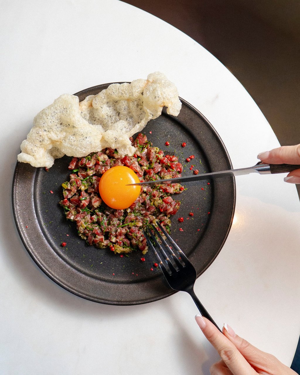 Sichuan beef tartare with a confit egg yolk and beef tendon crackers at Marrow. Photo: courtesy Marrow Sichuan beef tartare with a confit egg yolk and beef tendon crackers at Marrow. Photo: courtesy Marrow