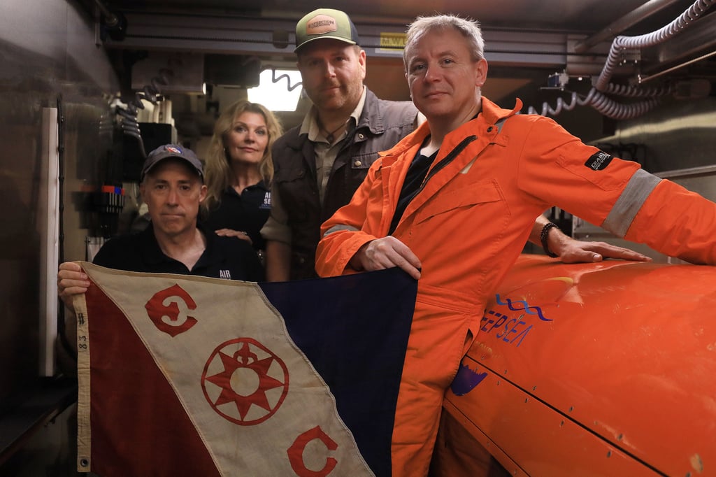 Members of the expedition team pose with their underwater sonar drone. Photo: Discovery Channel via AP Members of the expedition team pose with their underwater sonar drone. Photo: Discovery Channel via AP