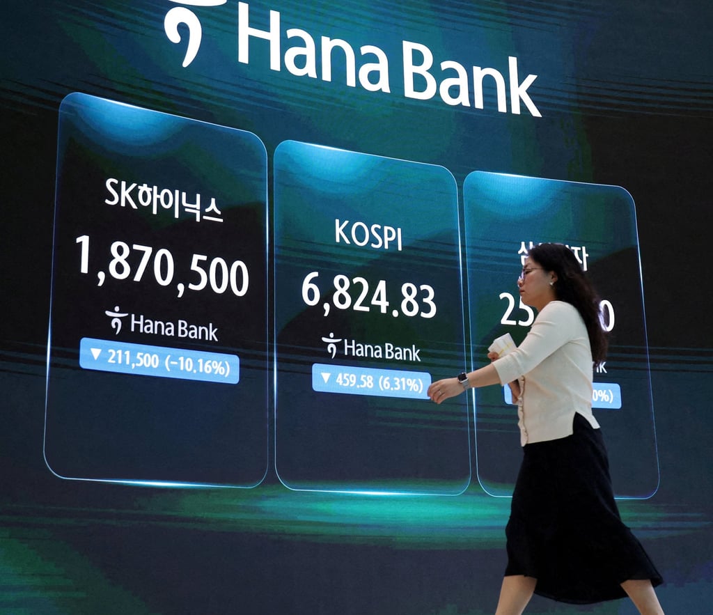 A currency dealer walks in front of an electronic board displaying SK Hynix and Samsung Electronics stock prices and the Korea stock index at the dealing room of a bank in Seoul on July 16. Photo: Reuters