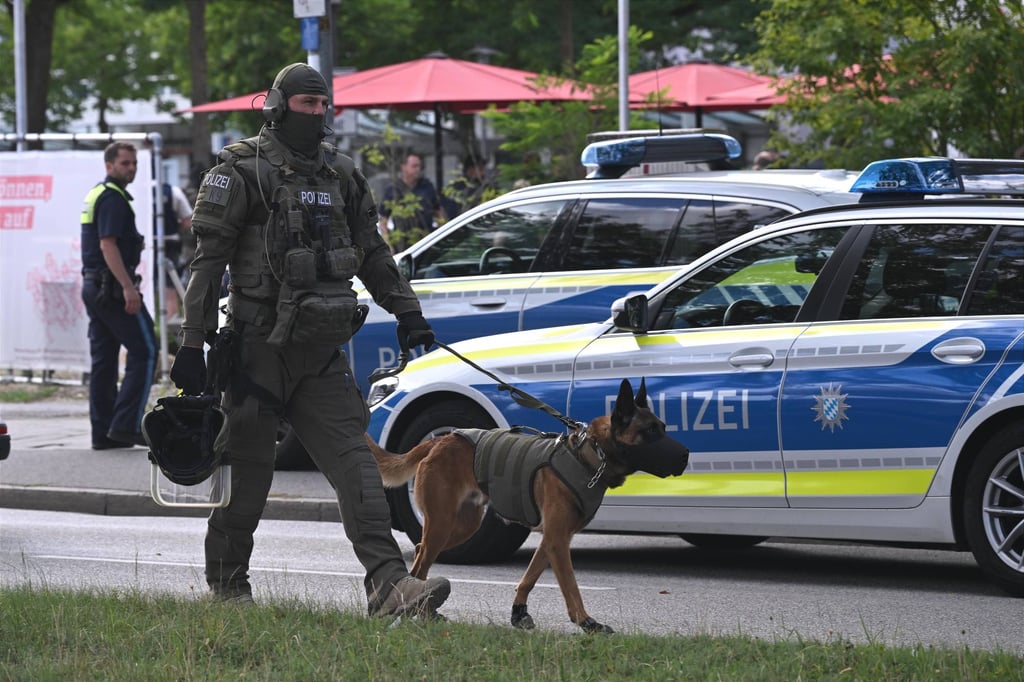 An officer and police dog are seen near a bank branch in Regensburg, Germany, where a man was fatally stabbed on Thursday. Photo: dpa