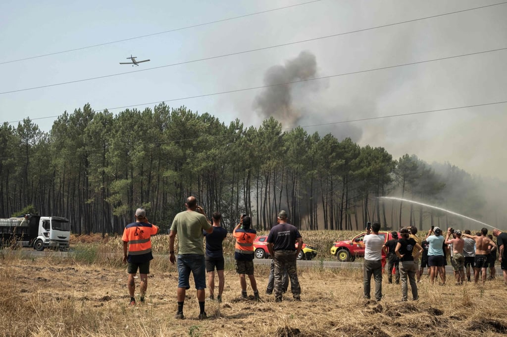 Volunteers and bystanders watch as firefighters tackle a forest fire in Lanton, southwestern France on Wednesday. Photo: AFP Volunteers and bystanders watch as firefighters tackle a forest fire in Lanton, southwestern France on Wednesday. Photo: AFP