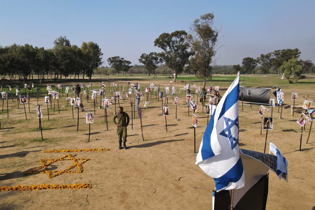 Israeli soldiers in December 2023 walk among photos of people taken captive or killed by Hamas militants during a music festival on October 7 that year, at the site where the massacre took place. Photo: AFP Israeli soldiers in December 2023 walk among photos of people taken captive or killed by Hamas militants during a music festival on October 7 that year, at the site where the massacre took place. Photo: AFP