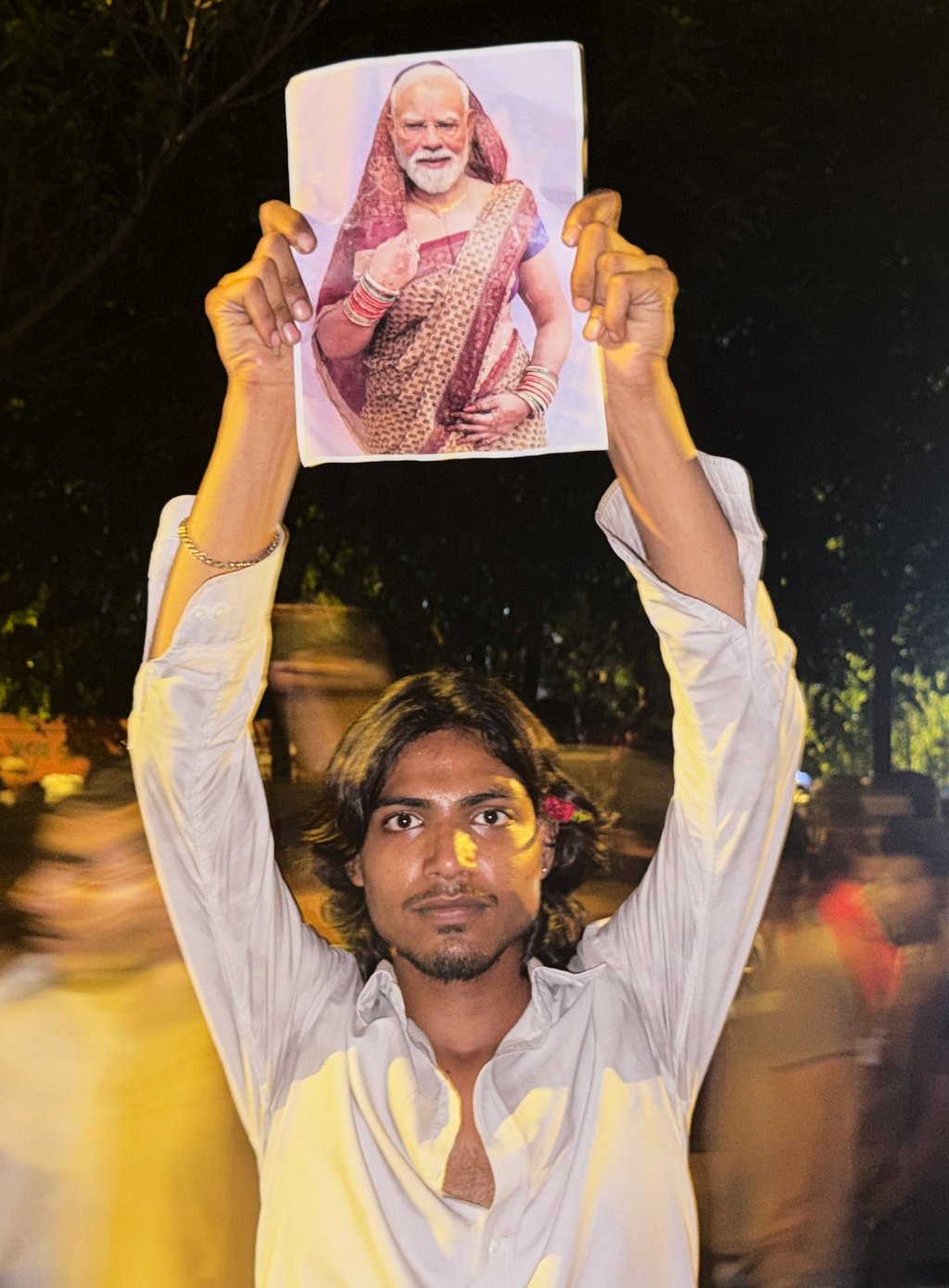 A protester holds a placard with a portrait of Prime Minister Narendra Modi in a sari in New Delhi on July 23. Photo: AP