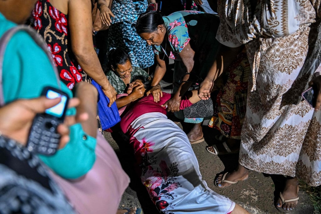 A relative of a Mahara Prison riot victim faints in grief on Saturday. Photo: AFP