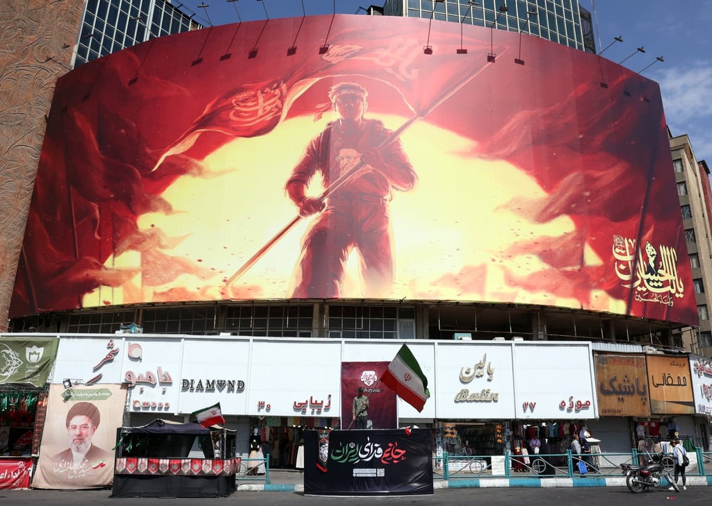 An Iranian man waves the national flag in front of a large political hoarding at Valiasr Square in Tehran on Saturday. Photo: EPA An Iranian man waves the national flag in front of a large political hoarding at Valiasr Square in Tehran on Saturday. Photo: EPA