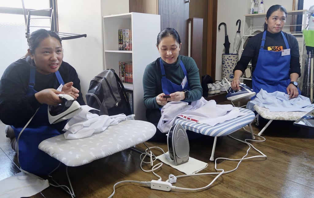 Filipino housekeeping staff learn the best way to use an iron during training in Tokyo’s Meguro ward in January. Photo: Kyodo