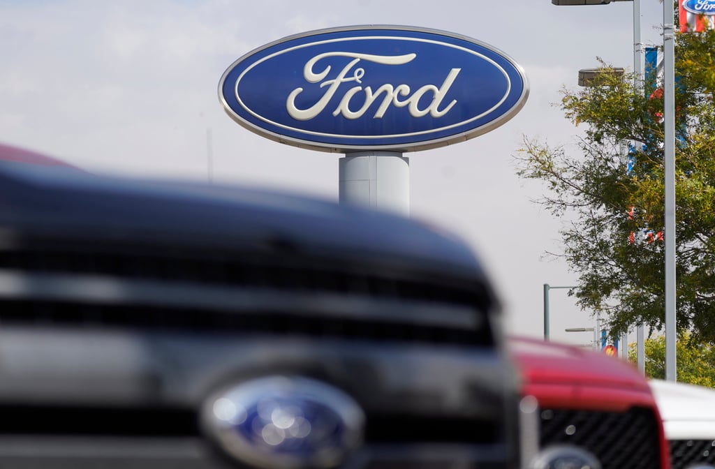 The Ford company logo is seen over a row of F-150 pickup trucks at a Ford dealership in Denver. Photo: AP